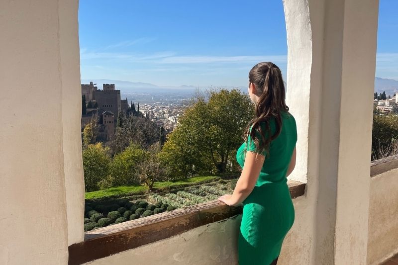 female student standing outside looking at a nice view of the sky